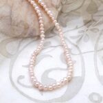 Chic Button Freshwater Pearl Necklace, cross drilled, in delicate shades of peach and plum by Pearl Perfect Design Room.