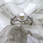 Delicate Pearl Diamond Ring set with Cultured Freshwater Pearl with Halo & Circle Shoulders pave set with Accent Diamonds. Designed in 18ct White Gold - Freshwater Pearl measures 7mm - Diamond Weight 0.20 carat - Unique Pearl Diamond Ring White Gold.