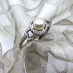 Delicate Pearl Diamond Ring set with Cultured Freshwater Pearl with Halo & Circle Shoulders pave set with Accent Diamonds. Designed in 18ct White Gold - Freshwater Pearl measures 7mm - Diamond Weight 0.20 carat - Unique Pearl Diamond Ring White Gold.