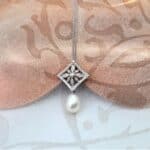Vintage style Pearl Diamond Pendant in 9ct White Gold with Pave set Diamond Leaf Motif and Cultured Freshwater Drop Pearl. The Clothilda Pendant measures 27mm in length worn on 9ct white gold fine rollo chain.  Chain length 44cm. Diamond Weight - 0.20 carats.