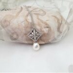 Vintage style Pearl Diamond Pendant in 9ct White Gold with Pave set Diamond Leaf Motif and Cultured Freshwater Drop Pearl. The Clothilda Pendant measures 27mm in length worn on 9ct white gold fine rollo chain.  Chain length 44cm. Diamond Weight - 0.20 carats.