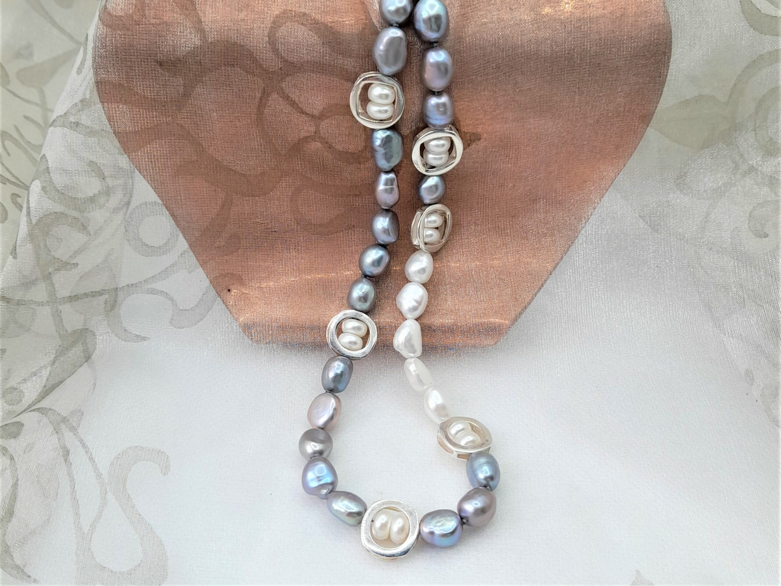 Striking contemporary Freshwater Pearl Necklace designed with a pattern of grey & white freshwater pearls & Sterling Silver elements framing button shape pearls,  in an asymmetrical pattern.   