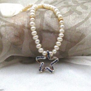 Charming star shape Pendant pave set with Sapphires in 9ct yellow gold worn on button shape Freshwater Pearl Necklace with 9ct gold bead detail. The Tilda pearls measure 4mm~ bright lustre with pinky white overtones ~ fitted with 9ct yellow gold trigger clasp. ~ Pendant measures 15mm ~Overall length of necklace 44cm.   