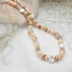 Pretty warm Peach & Plum colours in this Freshwater Pearl Necklace showcase the varied shapes of non-nucleated pearls, typically called Keshi by Pearl Perfect.