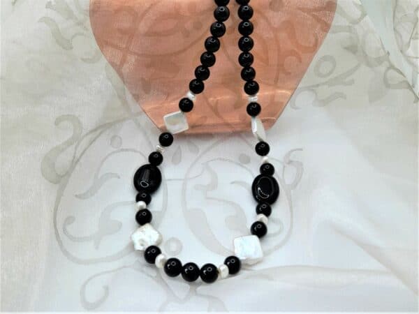 Onyx Freshwater Pearl Necklace, the feature Freshwater Pearls are square in shape contrasting with the oval and round highly polished Onyx beads. The necklace is finished with a Sterling Silver Clasp.